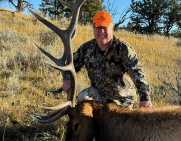 A male hunter with his management bull elk taken on our private land lease in Northeastern Wyoming